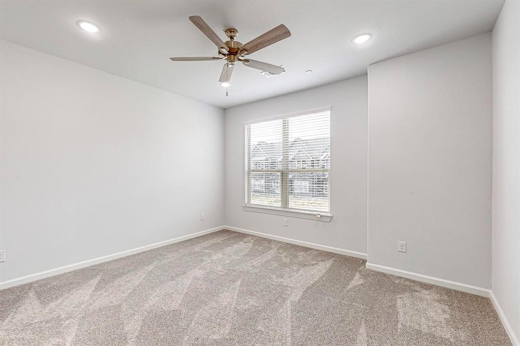 265 Buck Ridge Drive Frisco, TX 75068 - Photo 19 of 40 an empty room with a ceiling fan and windows