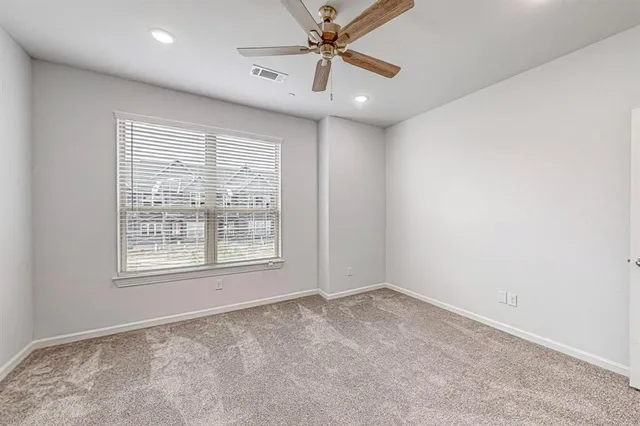 an empty room with a window and a fan