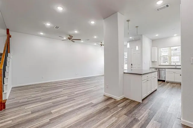 a large white kitchen with a white countertops a sink and a stove
