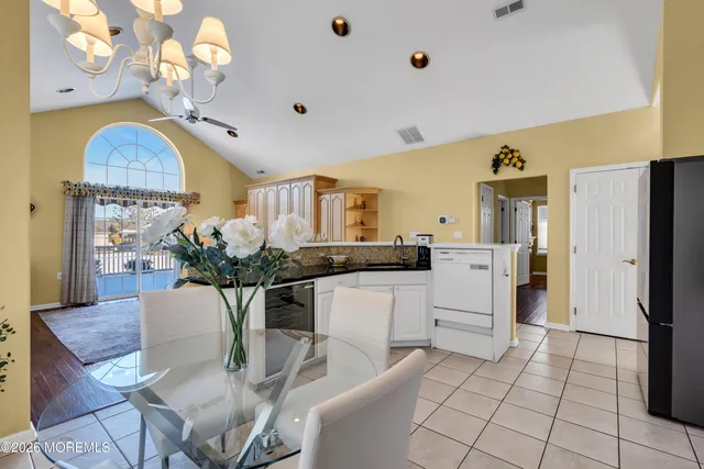 a kitchen with stainless steel appliances kitchen island granite countertop a refrigerator a stove a microwave oven with white cabinets and island