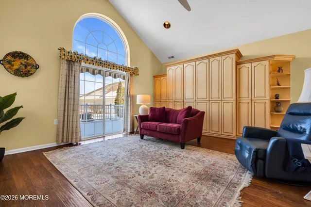 a living room with furniture a large window and a wooden floor
