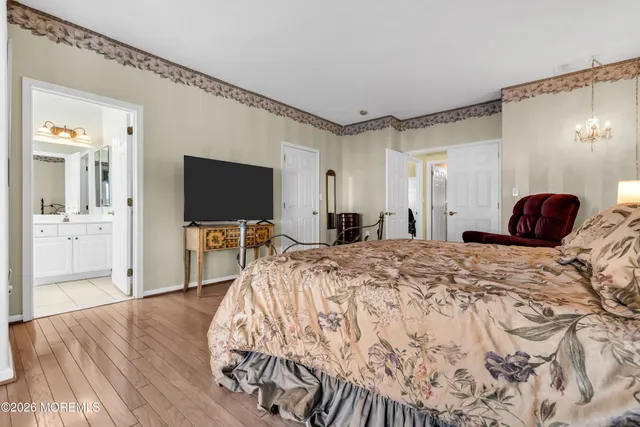 a spacious bedroom with a bed and a flat screen tv