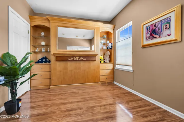 a view of a hallway with wooden floor and windows
