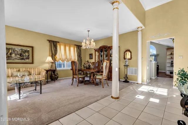 a living room with couches and a dining table with wooden floor
