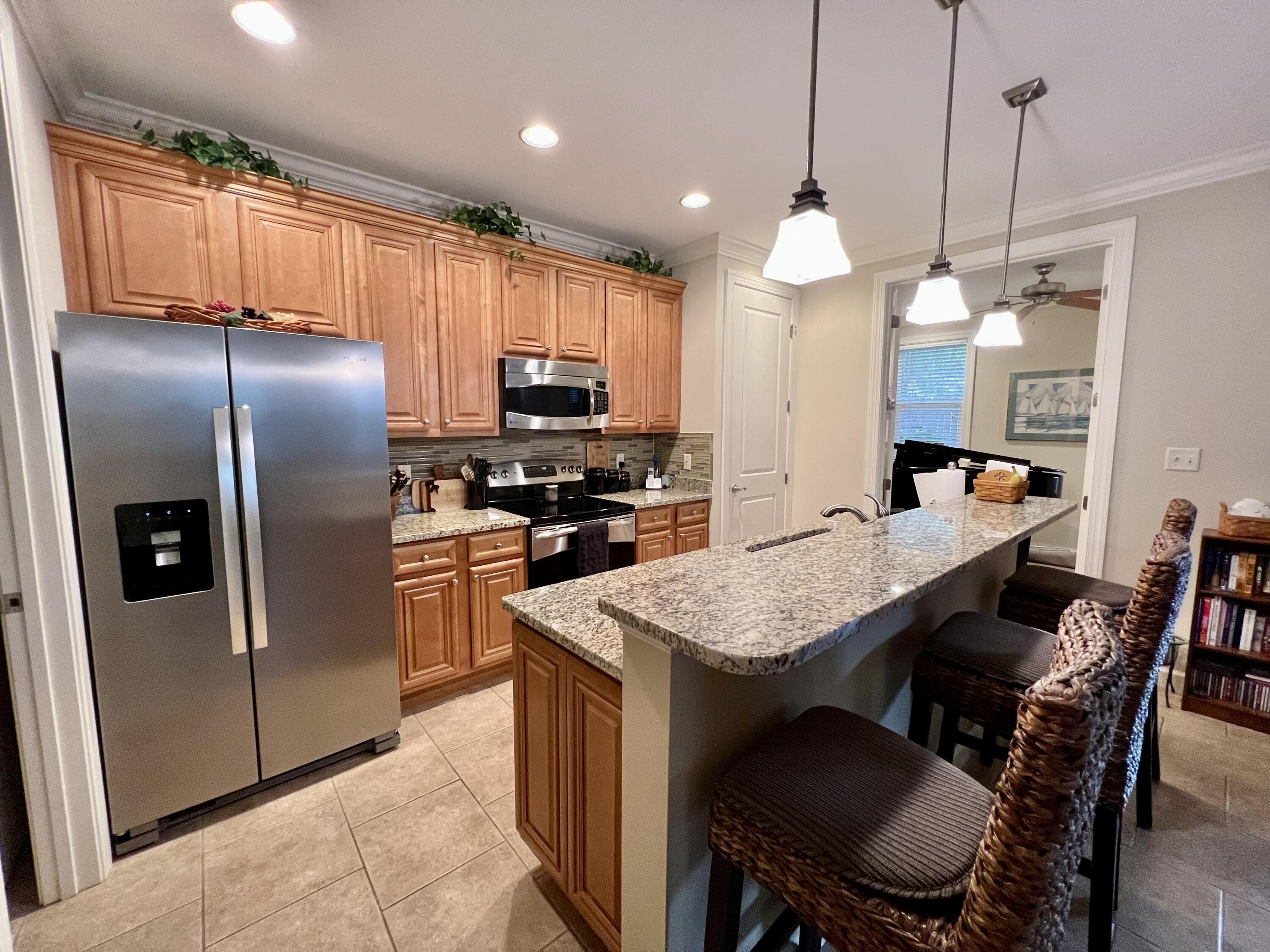 4248 Skipjack Cove Niceville, FL 32578 - Photo 14 of 64 a kitchen with stainless steel appliances granite countertop a stove refrigerator a table and chairs