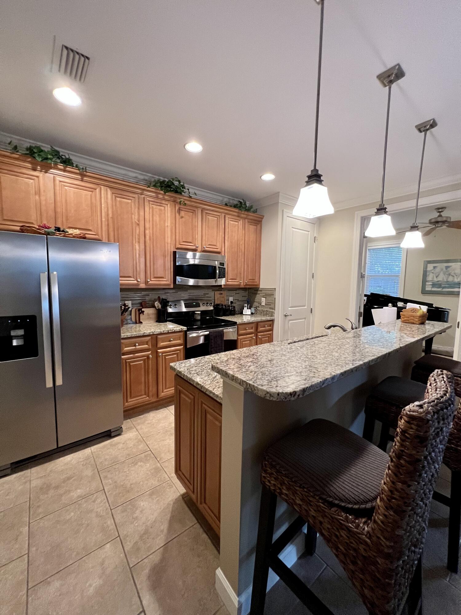 4248 Skipjack Cove Niceville, FL 32578 - Photo 15 of 64 a kitchen with stainless steel appliances granite countertop a sink a stove a refrigerator cabinets and chairs