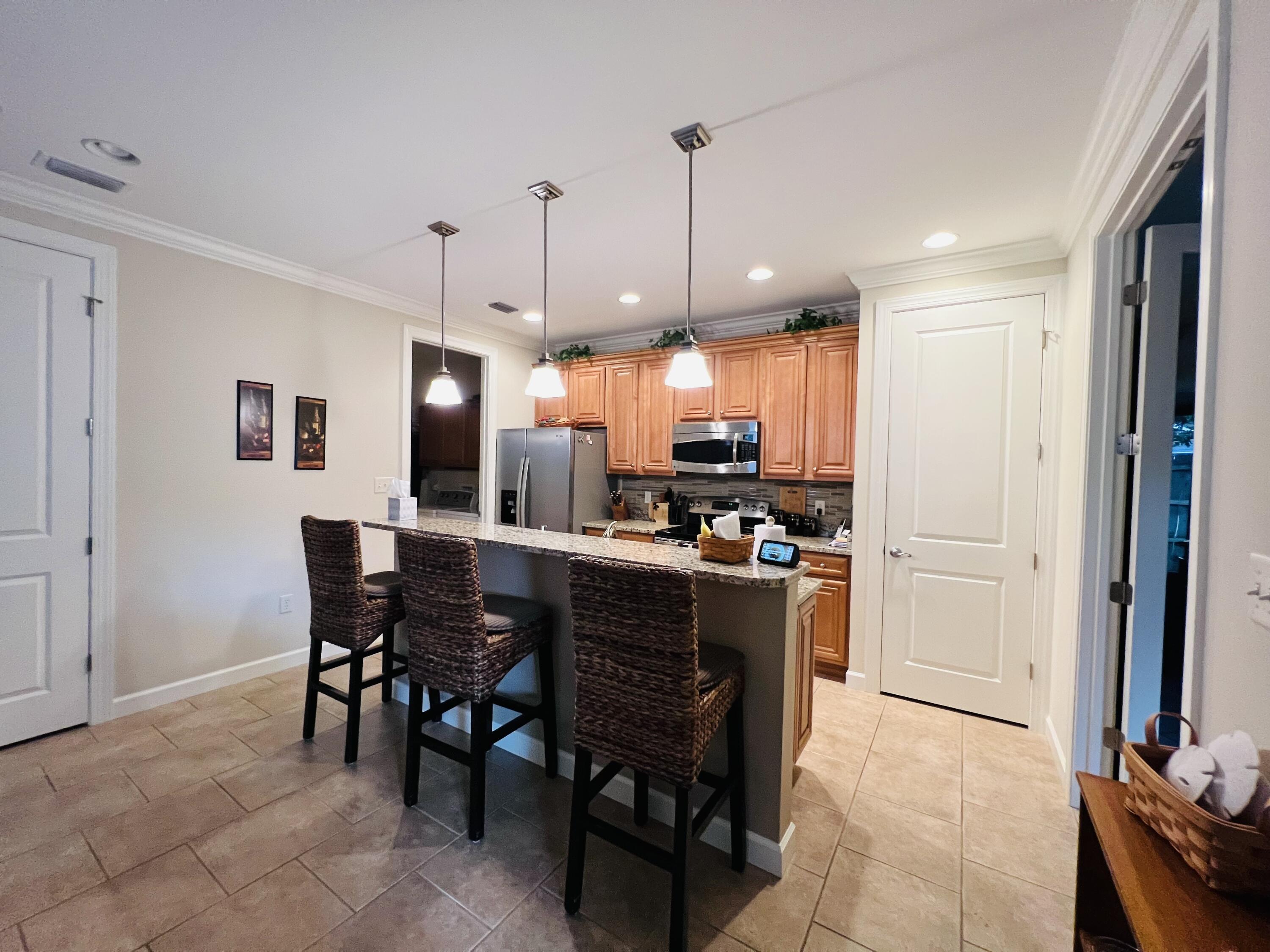 4248 Skipjack Cove Niceville, FL 32578 - Photo 22 of 64 a kitchen with kitchen island a dining table chairs stainless steel appliances and cabinets