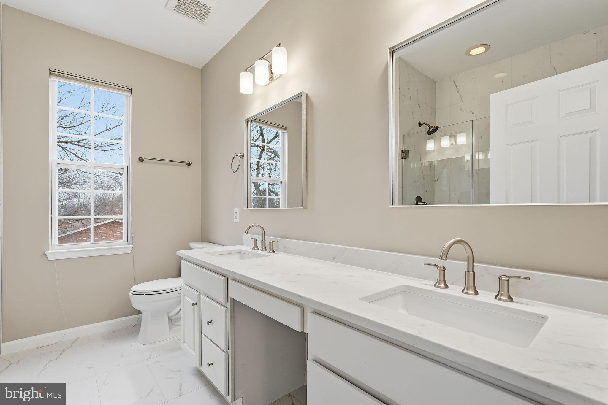 8310 Rolling Road Manassas, VA 20110 - Photo 34 of 58 a bathroom with a double vanity sink toilet and a mirror