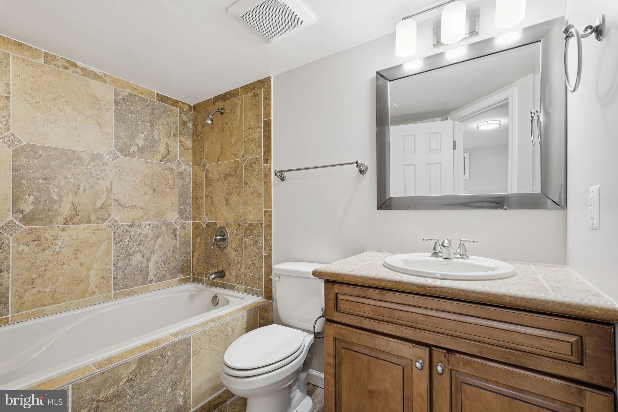 8310 Rolling Road Manassas, VA 20110 - Photo 42 of 58 a bathroom with a sink a toilet a mirror a bathtub and shower