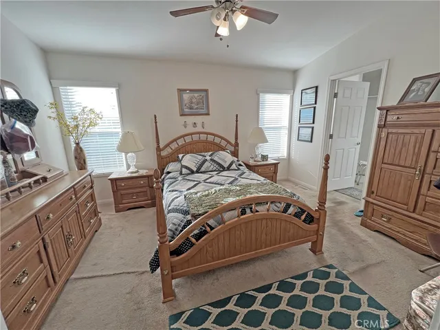 a bedroom with a bed and a flat tv screen on the dresser