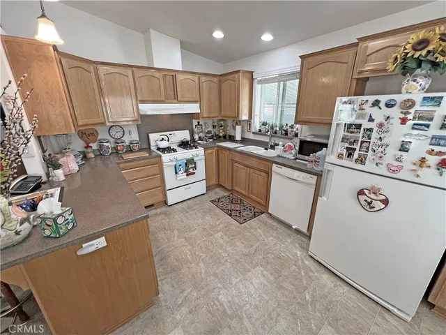 a kitchen with a refrigerator a stove top oven a sink and cabinets