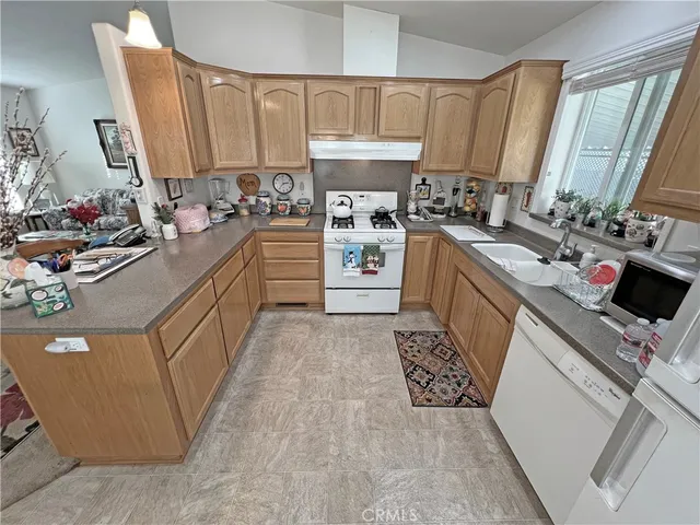 a kitchen with stainless steel appliances granite countertop a sink stove and cabinets
