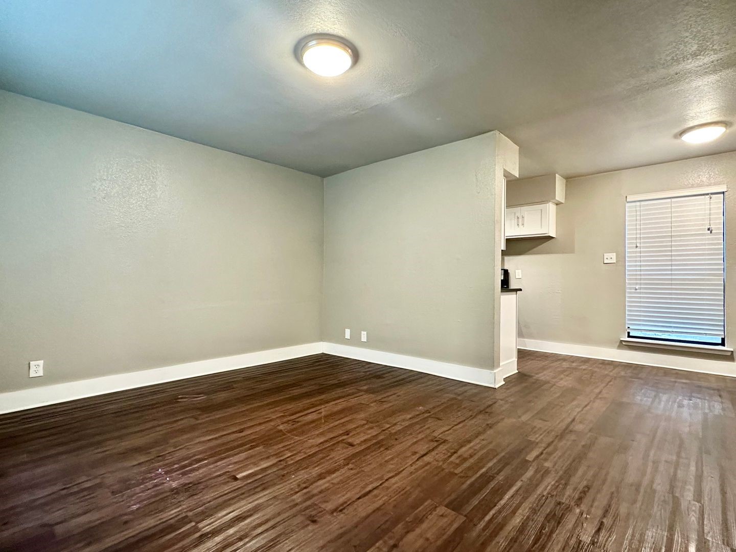 4316 Bull Creek Road, Unit 107 Austin, TX 78731 - Photo 4 of 8 The living area features wood flooring, a window with blinds, and recessed lighting