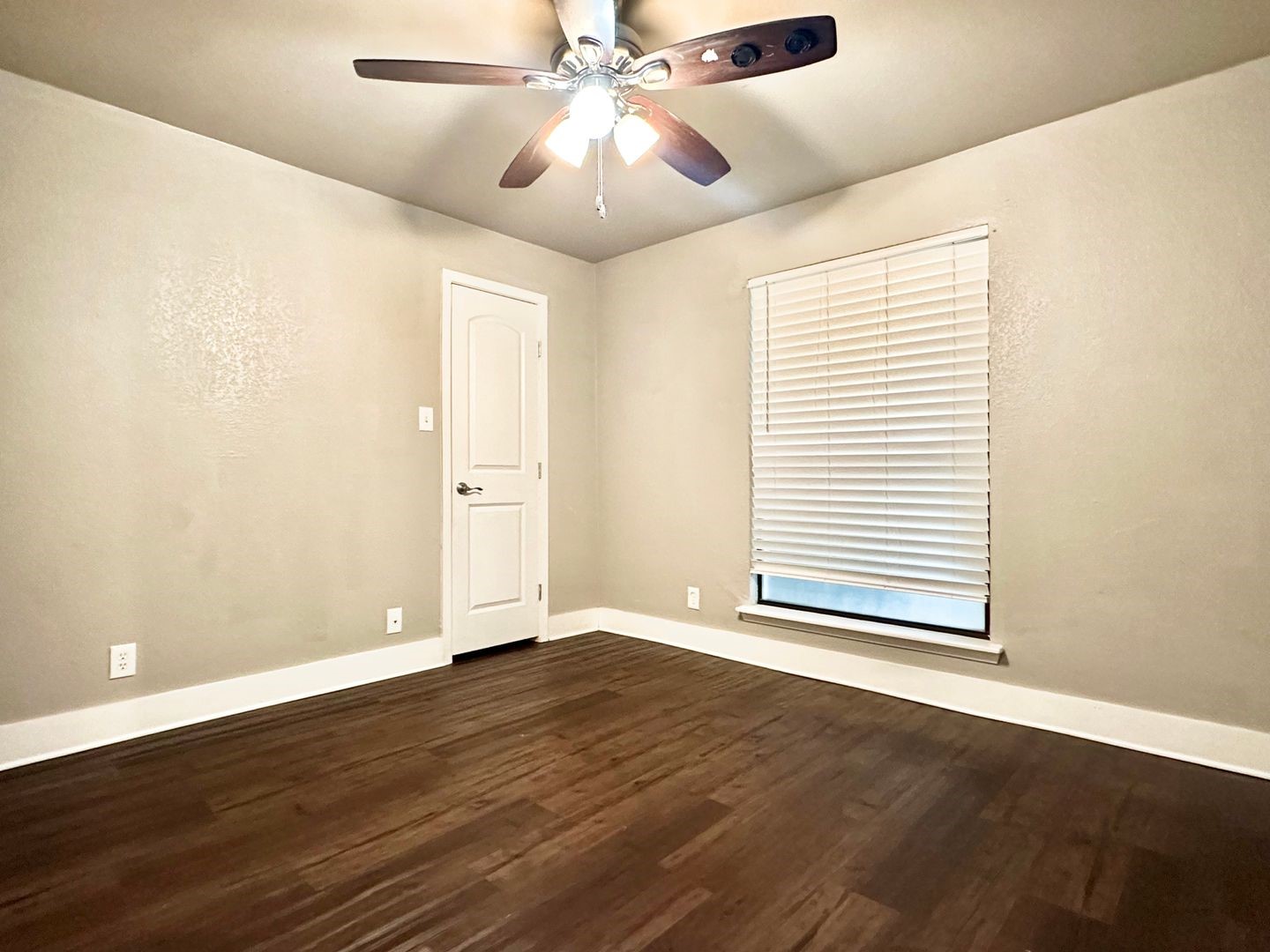 4316 Bull Creek Road, Unit 107 Austin, TX 78731 - Photo 6 of 8 This room features dark wood flooring, light-colored walls, and a ceiling fan with integrated lighting