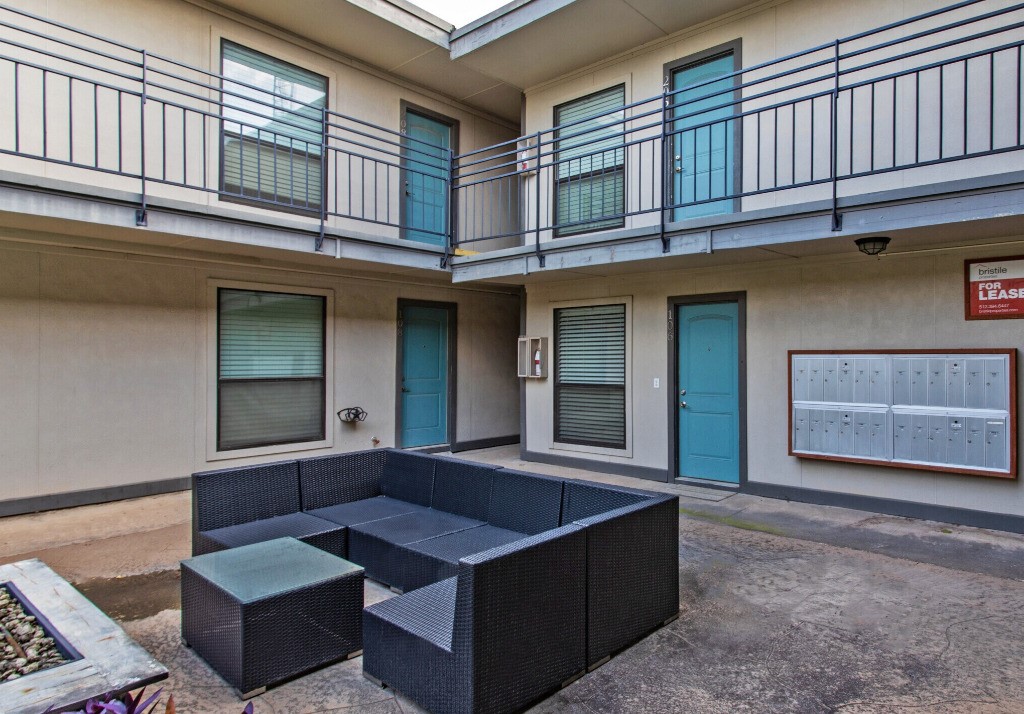 4316 Bull Creek Road, Unit 107 Austin, TX 78731 - Photo 8 of 8 The property features an exterior courtyard with a concrete patio, bordered by walls with individual unit entrances and windows