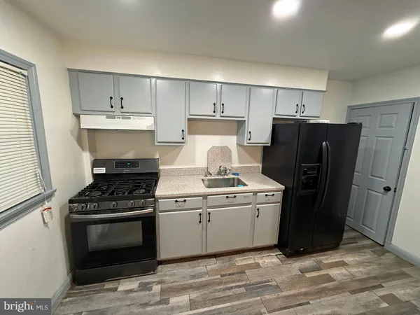 a kitchen with a stove top oven and refrigerator