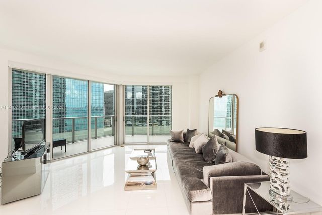 a living room with furniture and a floor to ceiling window