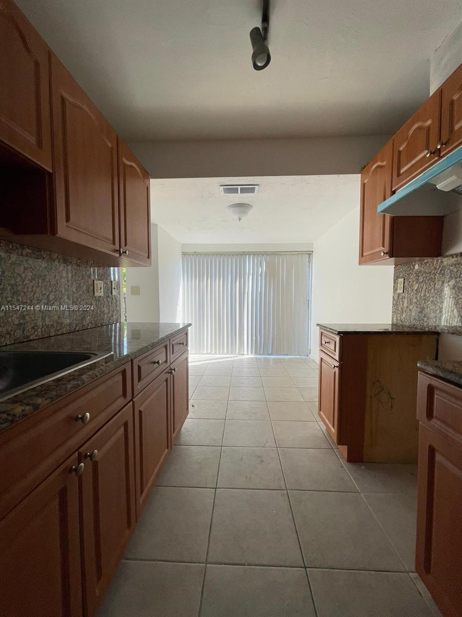 The Crossings Miami, FL 33186 - Photo 18 of 19 a kitchen with stainless steel appliances granite countertop a stove a sink and a microwave
