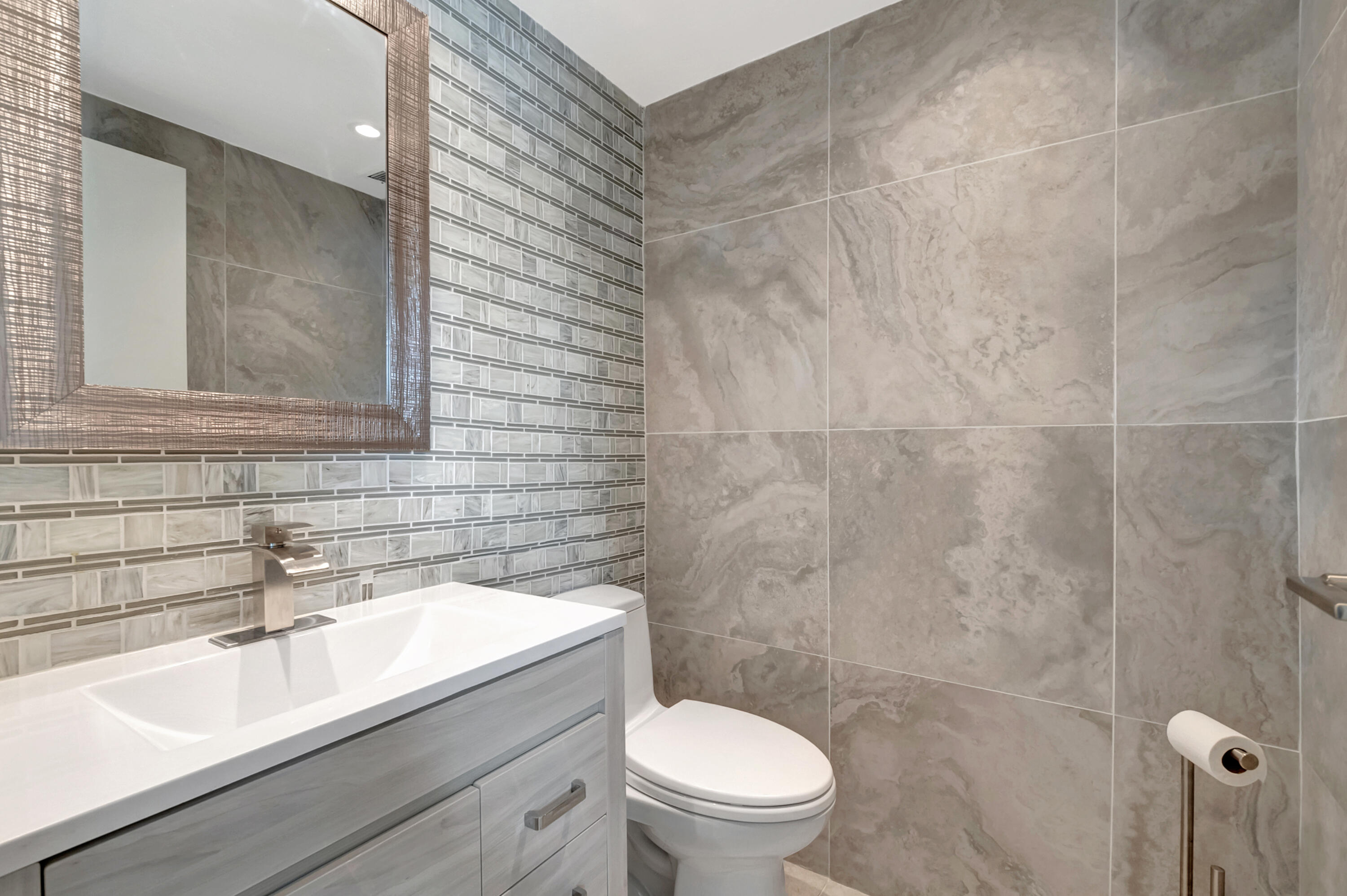 195 Monaco Way, Unit 195 Delray Beach, FL 33446 - Photo 16 of 64 a bathroom with a sink a toilet and mirror