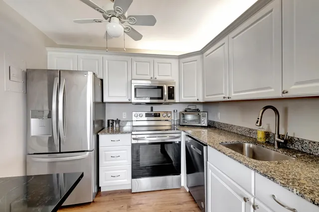 a kitchen with stainless steel appliances granite countertop a refrigerator sink and stove