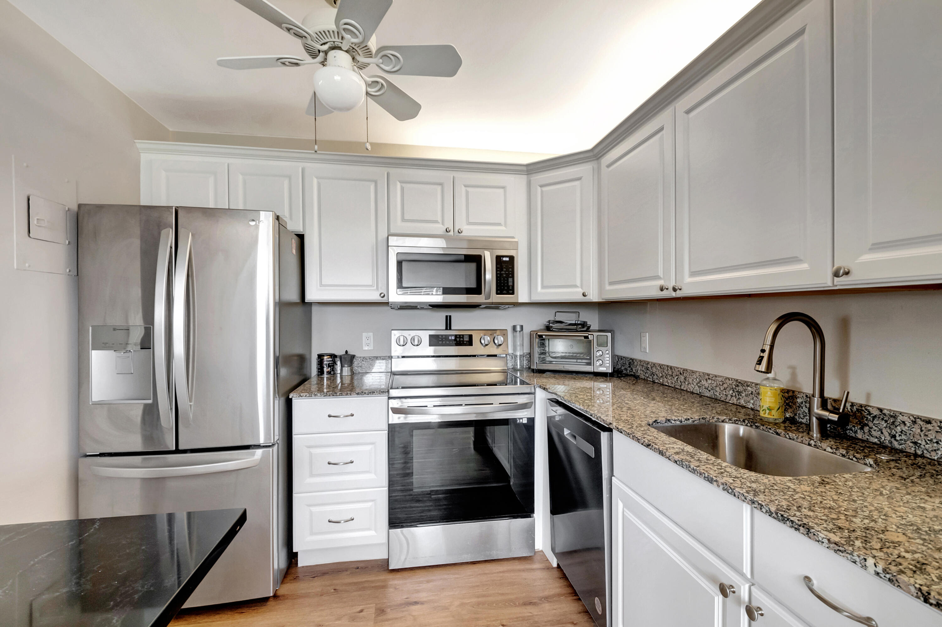 195 Monaco Way, Unit 195 Delray Beach, FL 33446 - Photo 10 of 64 a kitchen with stainless steel appliances granite countertop a refrigerator sink and stove