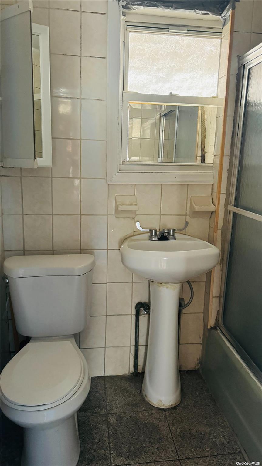 37-33 97th Street Queens, NY 11368 - Photo 12 of 14 a bathroom with a sink toilet and a mirror