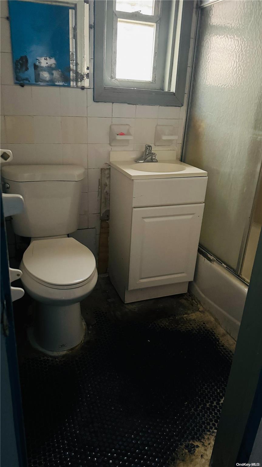 37-33 97th Street Queens, NY 11368 - Photo 13 of 14 a bathroom with a toilet sink and mirror