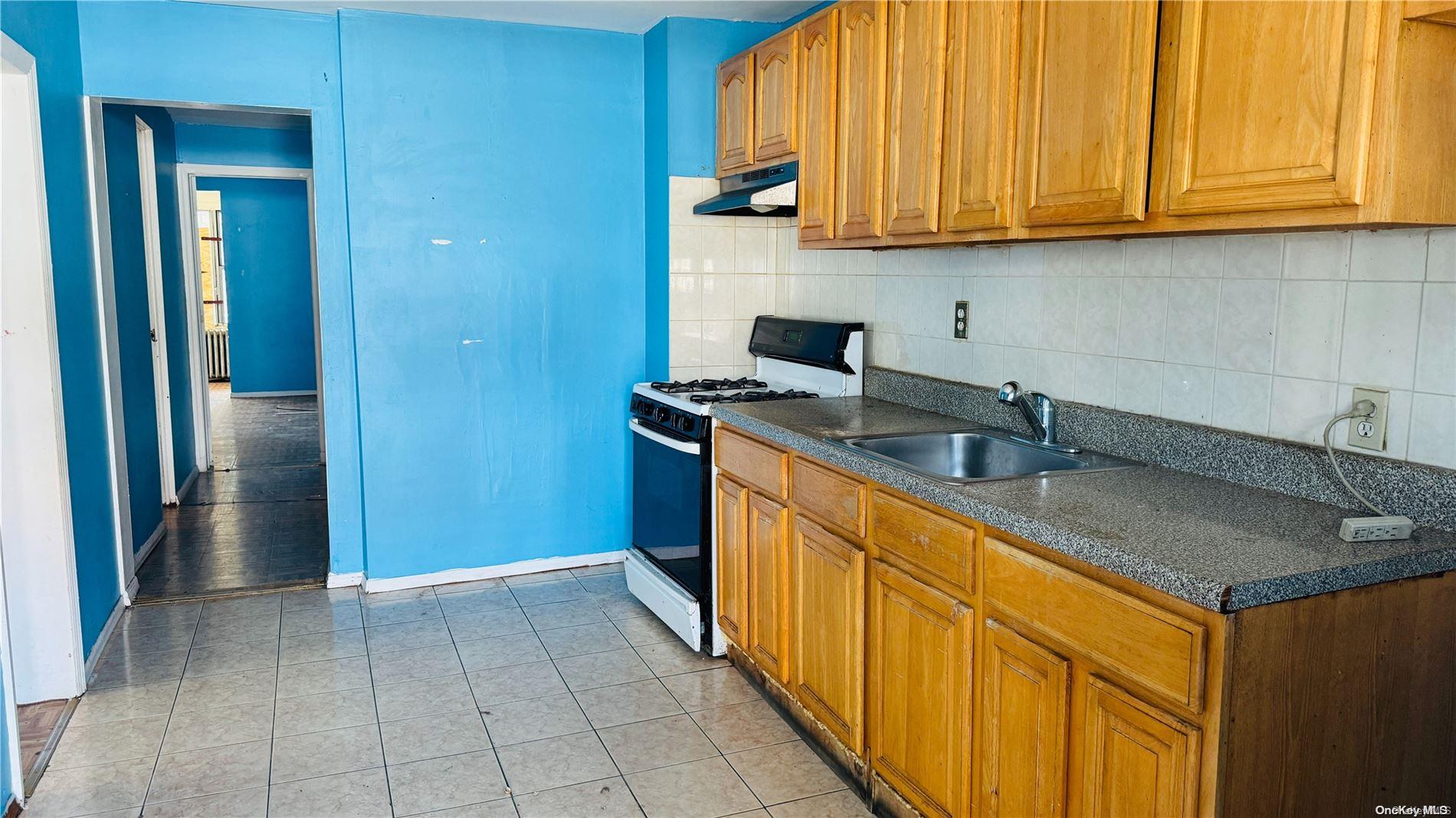 37-33 97th Street Queens, NY 11368 - Photo 8 of 14 a kitchen with stainless steel appliances granite countertop a sink and a refrigerator