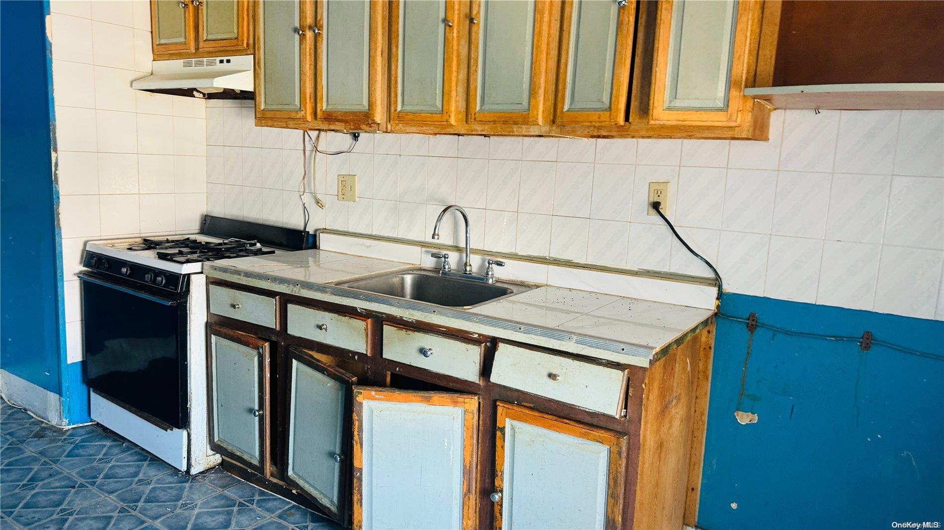 37-33 97th Street Queens, NY 11368 - Photo 9 of 14 a kitchen with stainless steel appliances granite countertop a sink and a stove