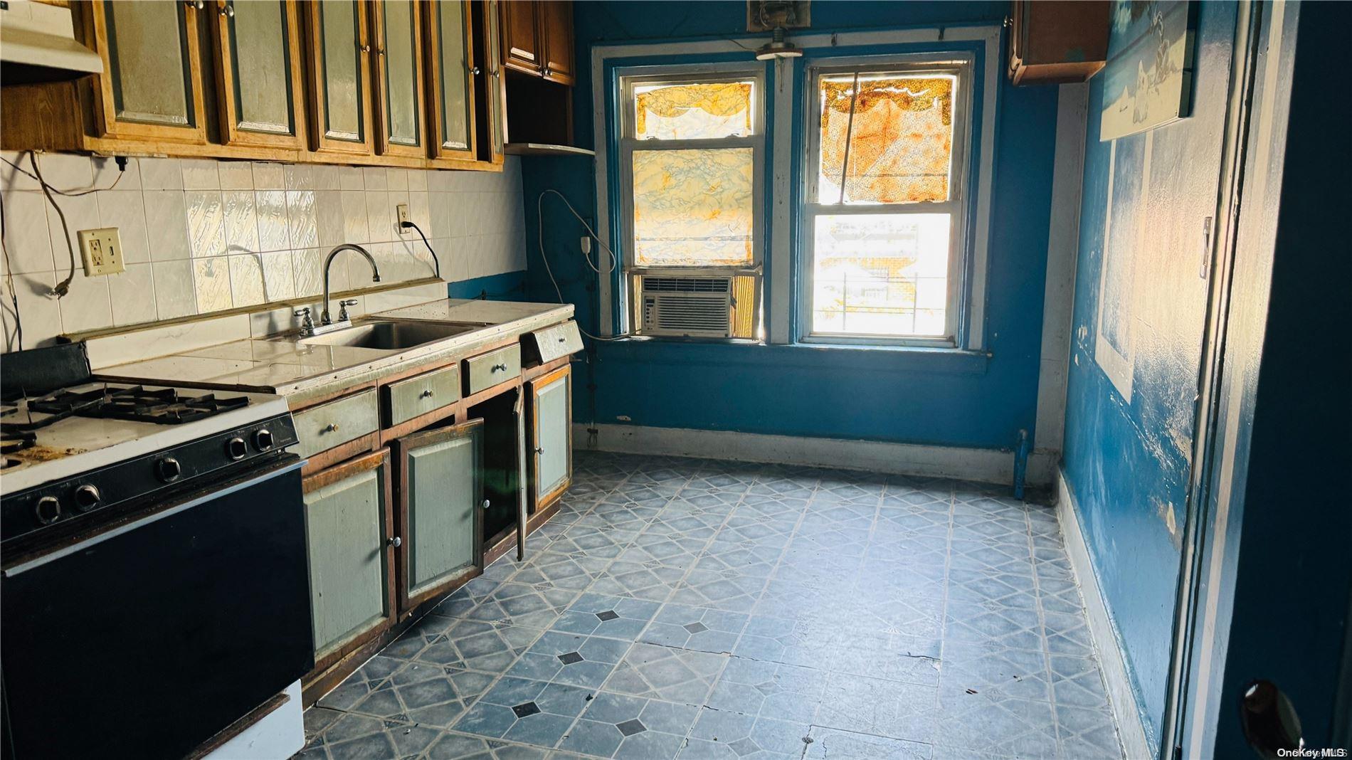 37-33 97th Street Queens, NY 11368 - Photo 10 of 14 a kitchen with stainless steel appliances granite countertop a stove a sink and a refrigerator