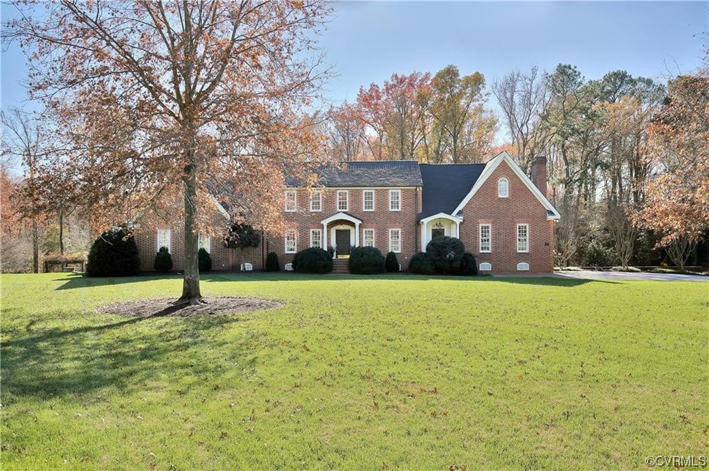 a front view of a house with a yard and trees