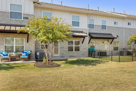 a view of a house with backyard and sitting area