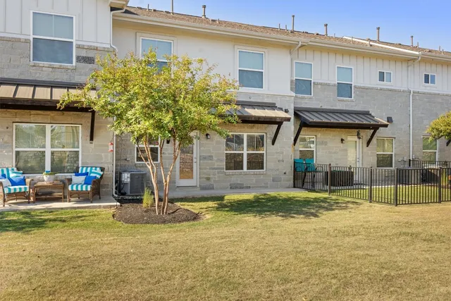 a view of a house with backyard and sitting area