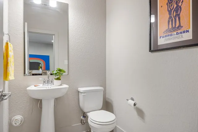a bathroom with a toilet sink and mirror