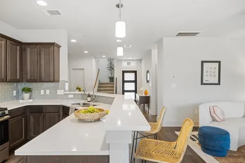 a kitchen with stainless steel appliances granite countertop a sink a stove and a wooden cabinets