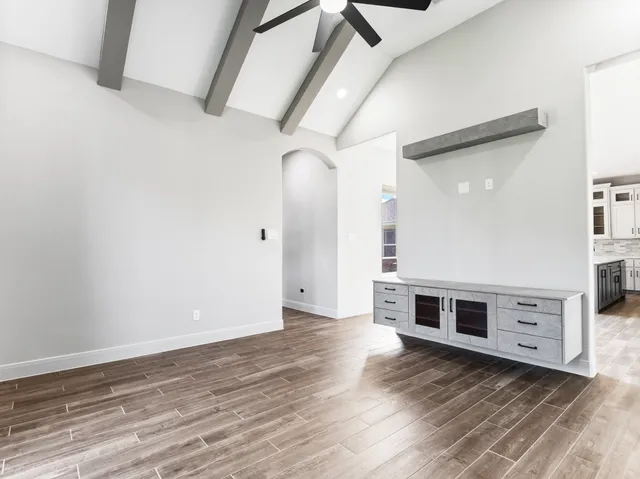 a view of a livingroom with wooden floor and electronic appliances