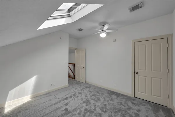 a view of a hallway with wooden floor and a bathroom