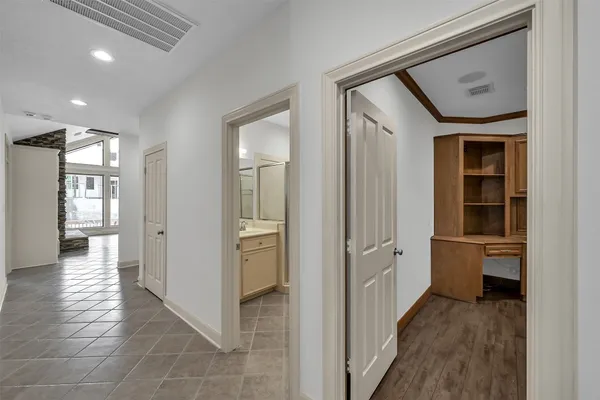 a living room with stainless steel appliances wooden floors and white walls