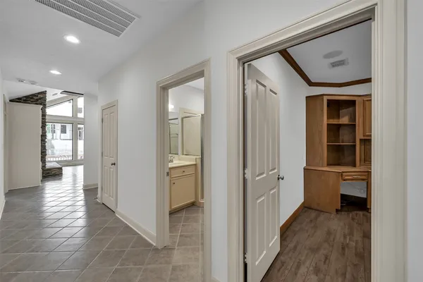 a living room with stainless steel appliances wooden floors and white walls