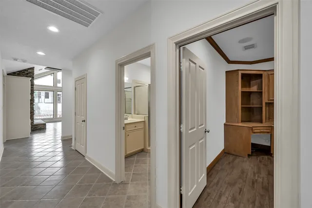 a living room with stainless steel appliances wooden floors and white walls