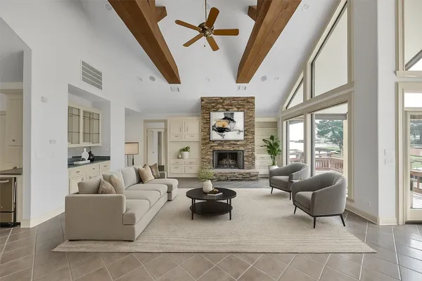 a living room with furniture a fireplace and a large window