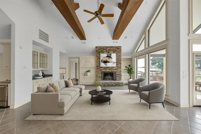 a living room with furniture a fireplace and a large window