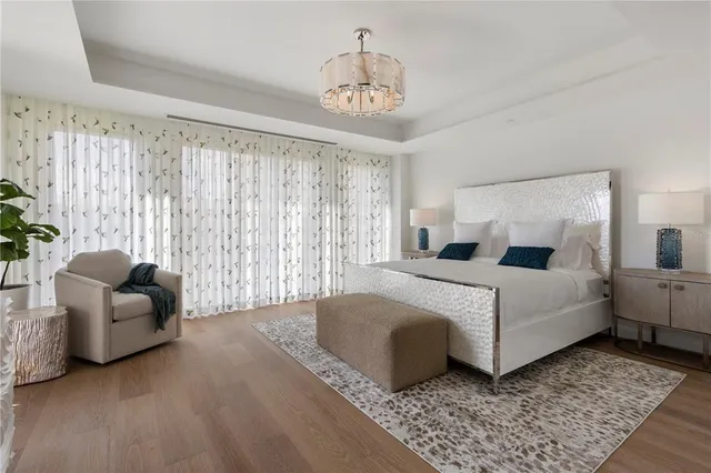 a bedroom with a large bed and a chandelier