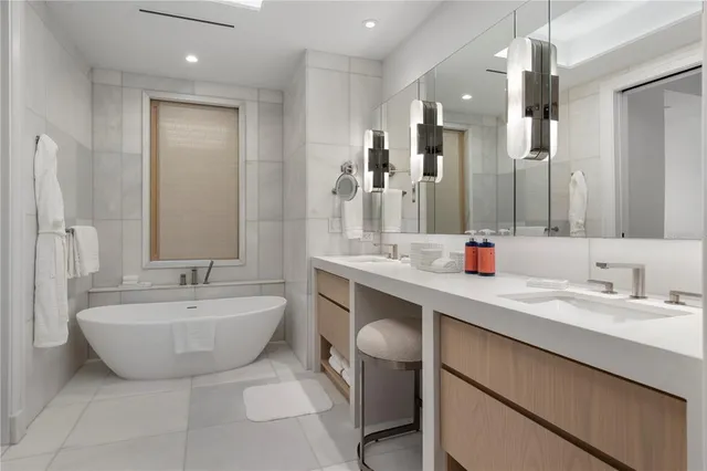 a spacious bathroom with a double vanity sink mirror and bathtub
