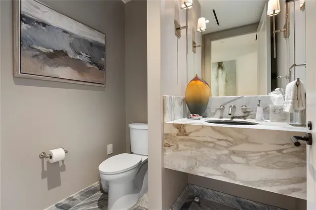 a bathroom with a toilet a sink and mirror