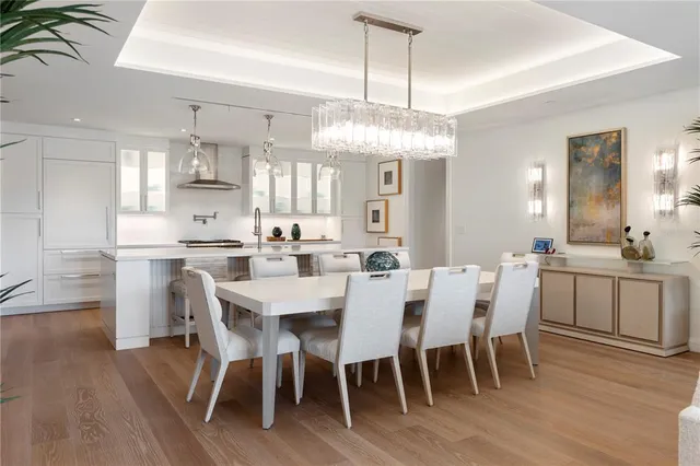 a view of a dining room with furniture a chandelier and wooden floor