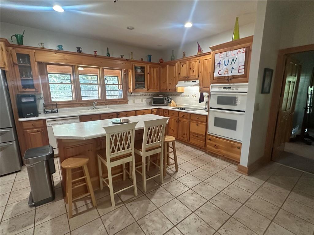 8275 Pea Ridge Road Cornelia, GA 30531 - Photo 13 of 52 a kitchen with stainless steel appliances granite countertop a stove top oven island a table and chairs