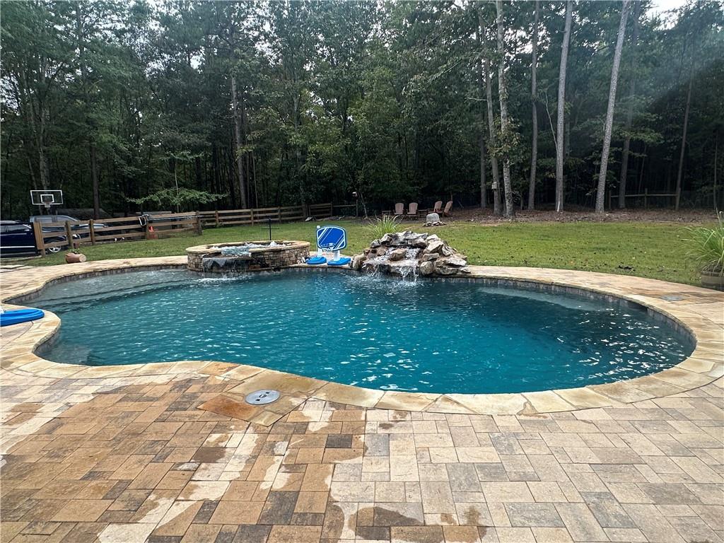 8275 Pea Ridge Road Cornelia, GA 30531 - Photo 32 of 52 a view of a swimming pool with a sitting space
