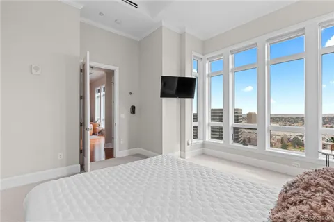 a bedroom with a bed and a large window