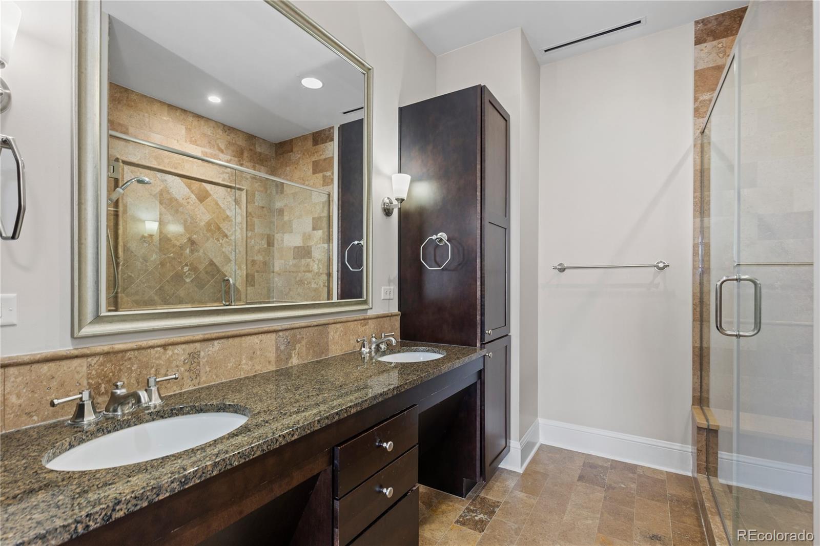 7600 Land Mark Way, Unit 1411 Greenwood Village, CO 80111 - Photo 29 of 50 a bathroom with a granite countertop sink a mirror and shower